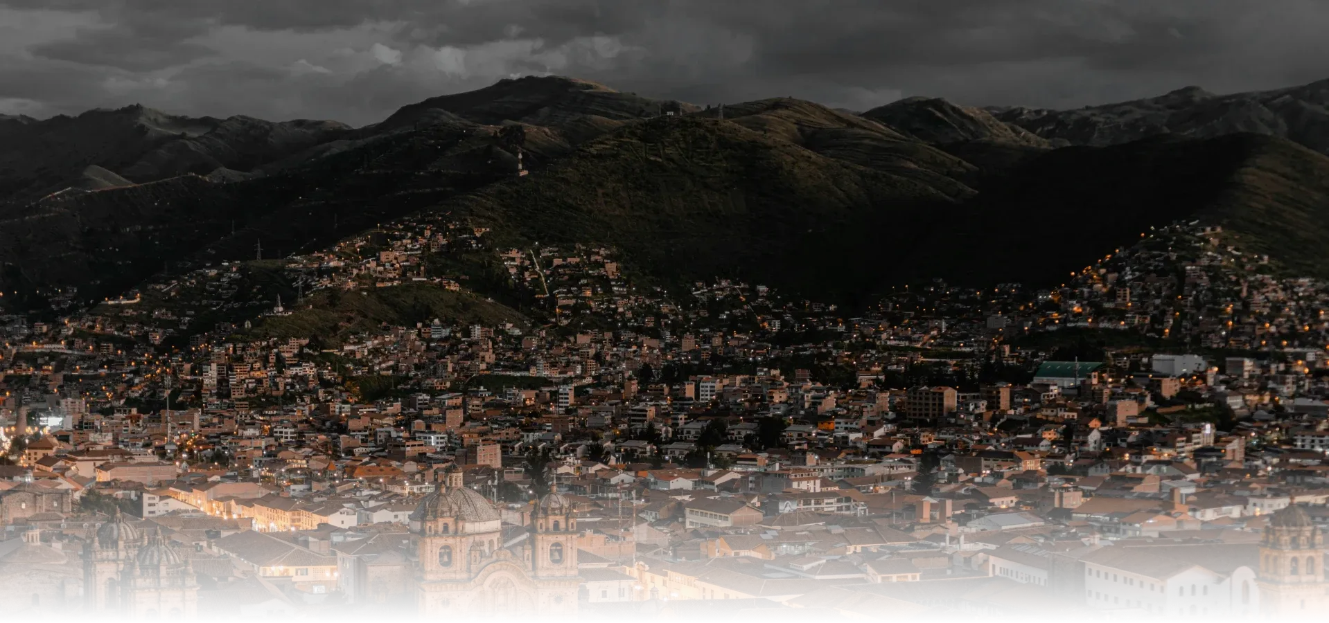 Vista panoramica de una ciudad peruana entre montañas al atardecer